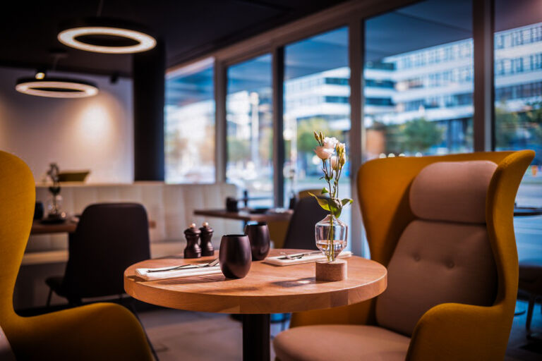 Modern eingerichteter Restaurantbereich mit gemütlichen Sesseln und stilvoll gedecktem Tisch.