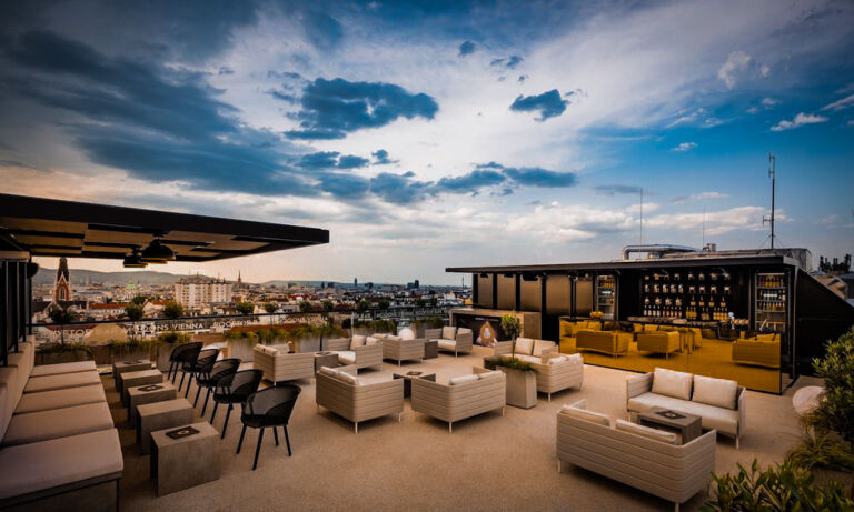 Elegante Rooftop-Bar mit stilvollen Sitzmöbeln und beeindruckendem Blick über die Stadt.